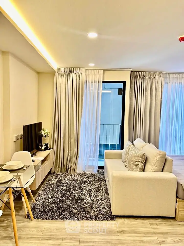 Modern living room with cozy sofa and stylish decor, featuring a sleek TV setup and elegant curtains.