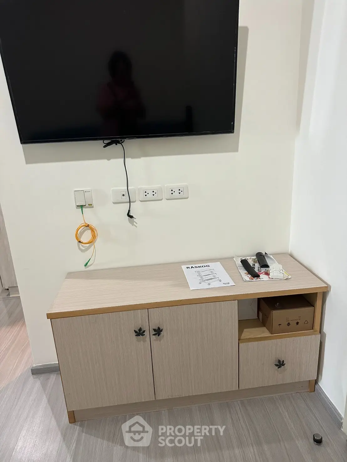 Modern living room with wall-mounted TV and stylish wooden cabinet