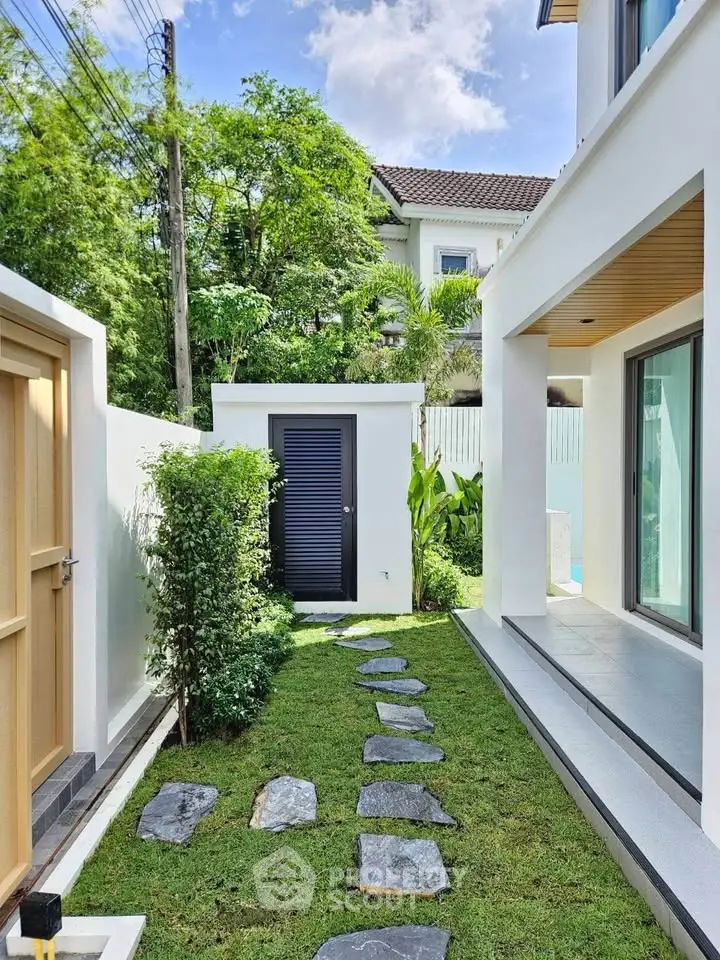Charming modern home exterior with lush garden and stone pathway, perfect for serene living.