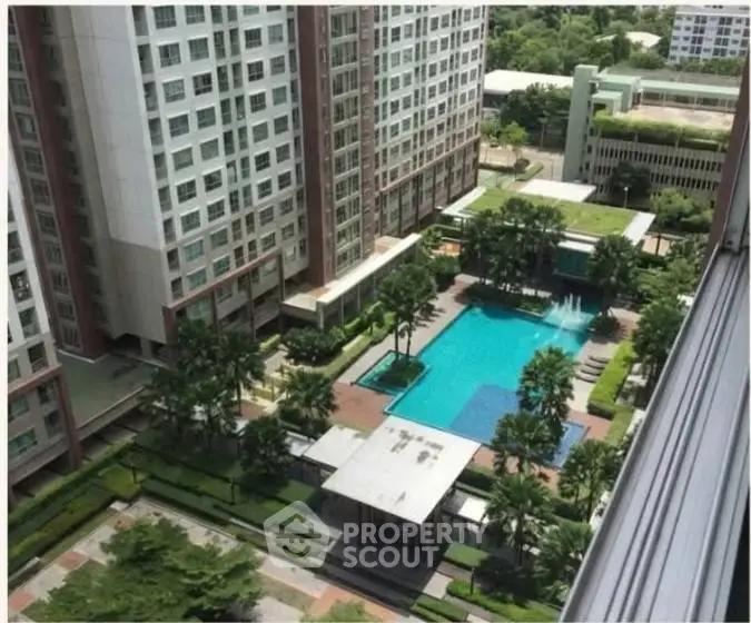 Stunning aerial view of modern apartment complex with lush garden and inviting pool area.