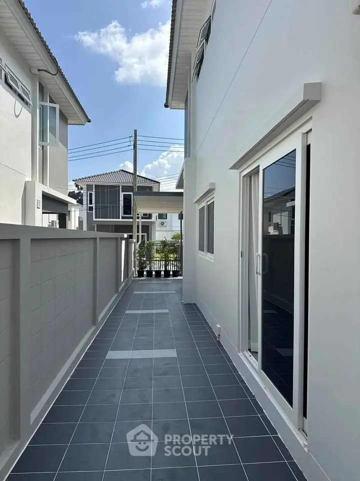 Modern townhouse exterior with sleek design and tiled walkway, perfect for urban living.