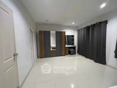 Spacious bedroom with modern wardrobe and sleek tile flooring