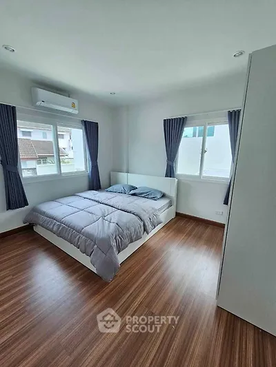 Spacious bedroom with modern decor and large windows for natural light