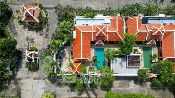 Stunning aerial view of luxury villa with red roofs and lush gardens.