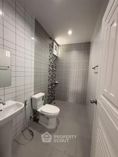 Modern bathroom with sleek tiles and contemporary fixtures in a real estate property.