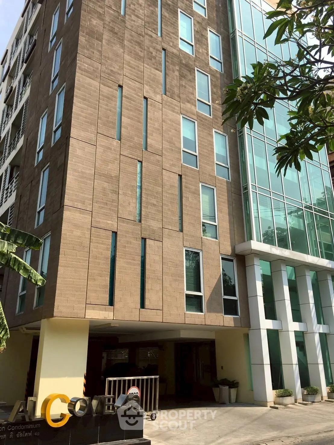 Modern condominium building exterior with sleek design and large windows in urban setting.
