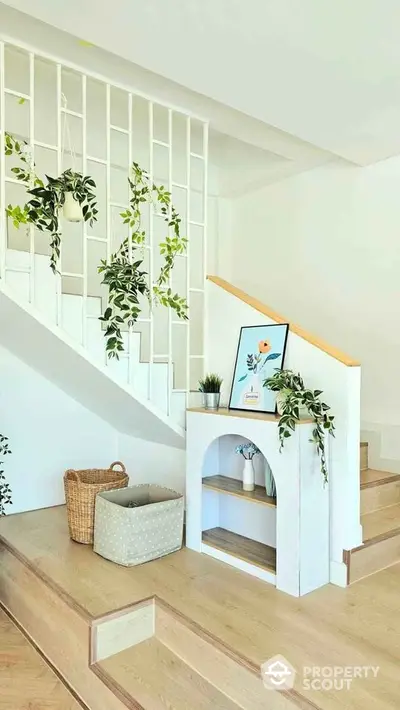 Stylish staircase with modern decor and indoor plants in a bright home interior.