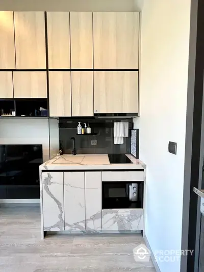 Modern kitchen with sleek cabinetry and marble countertops in a stylish apartment.