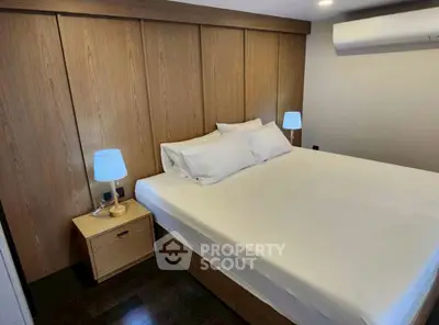 Modern bedroom with wooden paneling and cozy lighting