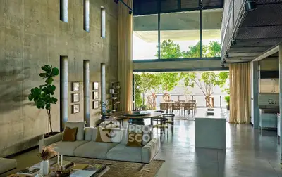 Luxurious modern living room with high ceilings and large windows overlooking a lush garden.