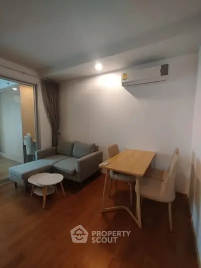 Modern living room with cozy sofa, dining table, and air conditioning in a stylish apartment.