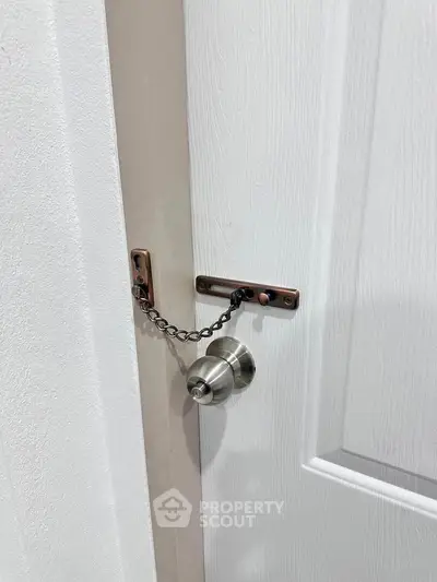 Secure interior door with chain lock and modern knob for enhanced safety.