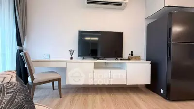 Modern living room with sleek TV setup and stylish furniture in a contemporary apartment.
