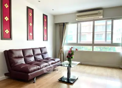 Bright modern living room with large windows, stylish sofa, and elegant decor in a contemporary apartment.