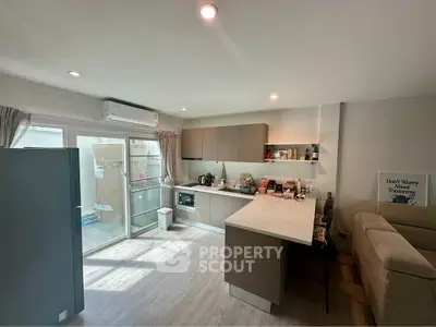 Modern kitchen with open layout and sleek design, featuring ample natural light and contemporary appliances.