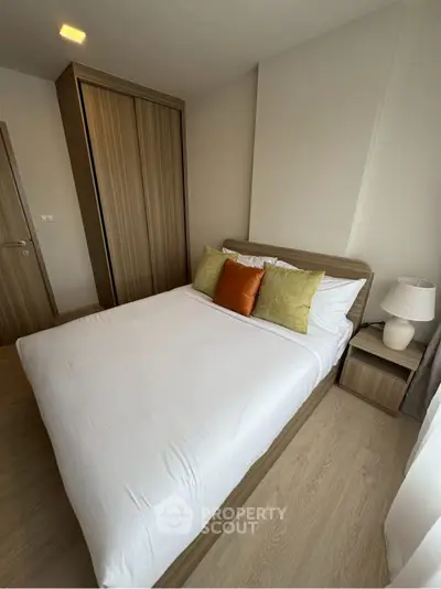 Cozy bedroom with modern wooden furniture and stylish decor in a contemporary apartment.