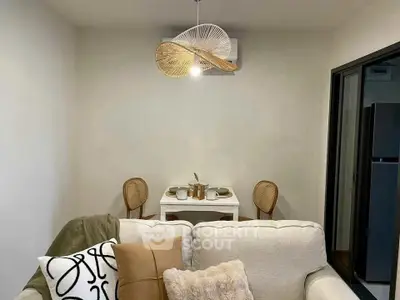 Cozy living room with modern decor and dining area, featuring stylish lighting and comfortable seating.