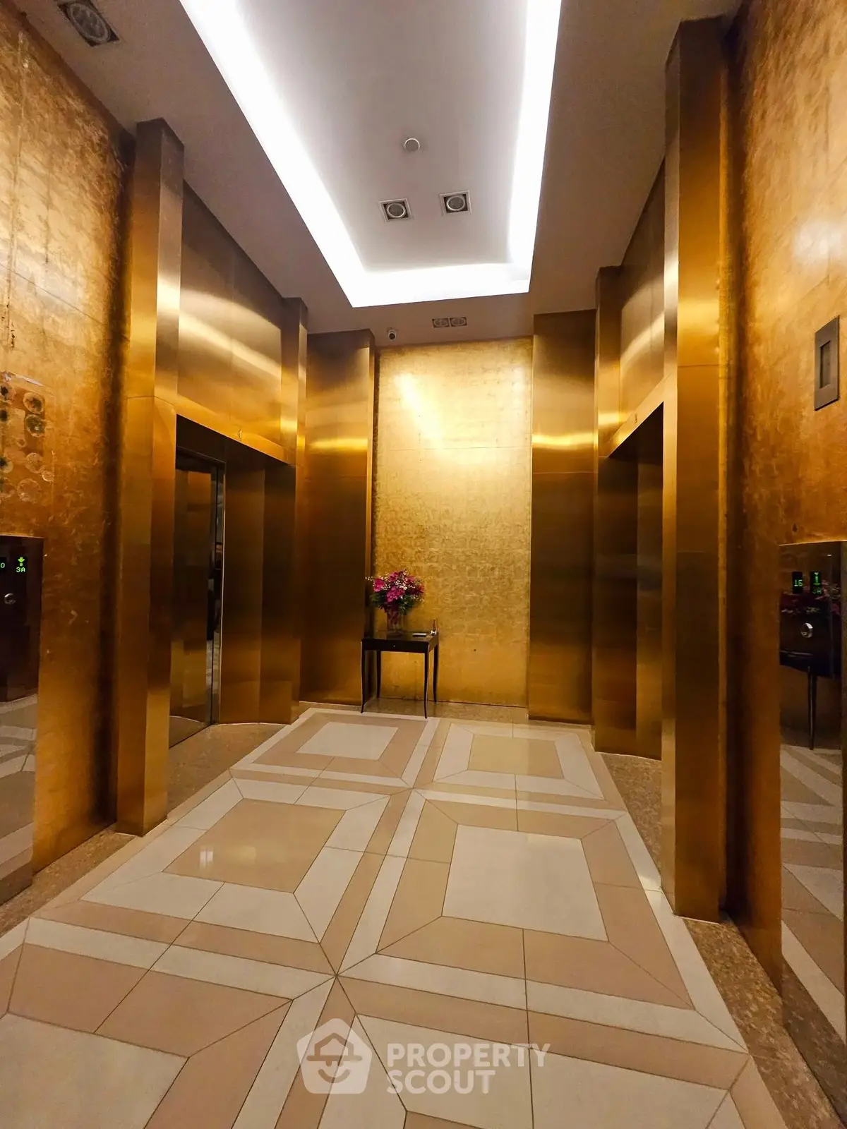 Luxurious golden elevator lobby with elegant floral arrangement