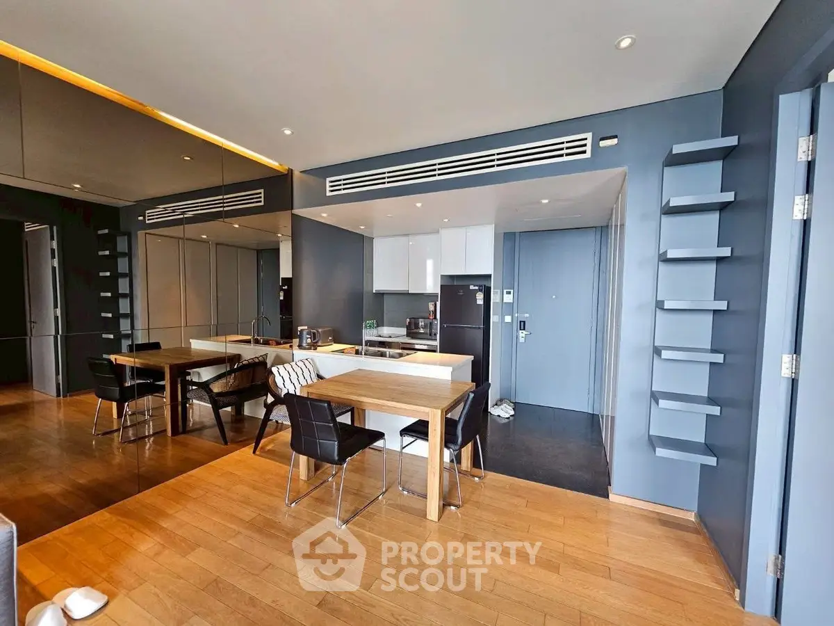 Modern open-plan kitchen and dining area with sleek design and wooden flooring.