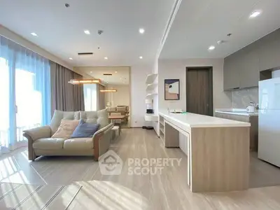 Spacious modern living room with open kitchen and large windows in a stylish apartment.