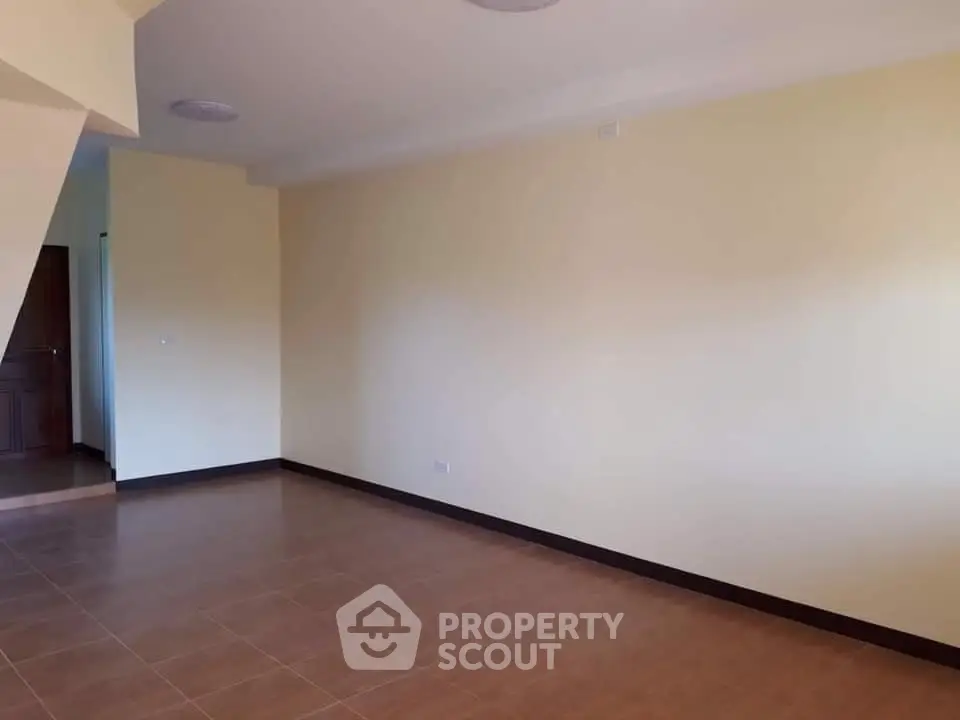 Spacious empty room with tiled floor and neutral walls, ideal for customization.