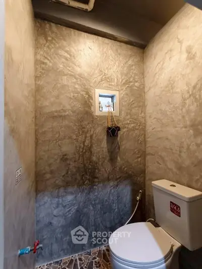Modern minimalist bathroom with concrete walls and small window
