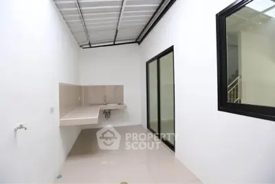 Spacious utility area with modern sink and tiled flooring in a bright, open space.