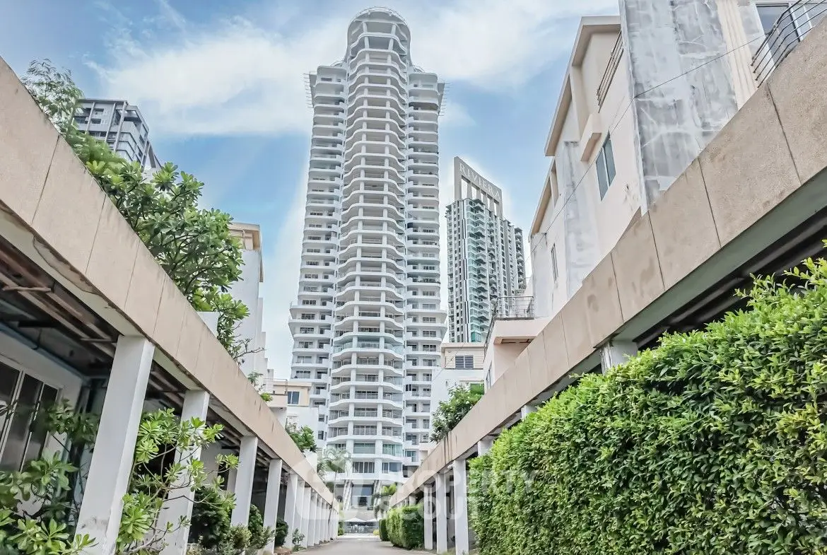 Stunning high-rise building with lush greenery and modern architecture in urban setting.