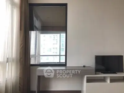 Modern minimalist living room with large window and sleek TV stand.