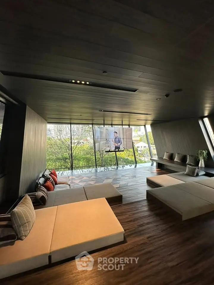 Luxurious modern living room with floor-to-ceiling windows and serene outdoor view.