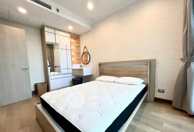 Modern bedroom with stylish decor and ample natural light, featuring a comfortable bed and sleek furnishings.