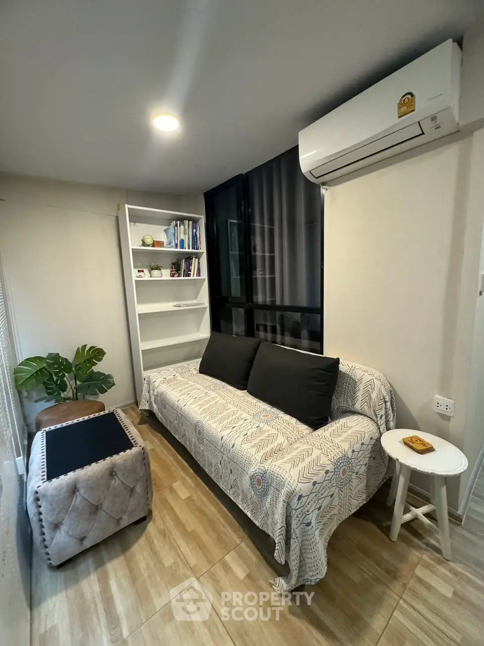 Cozy living room with stylish decor and modern air conditioning unit.