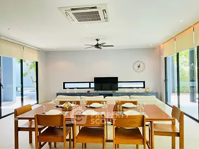 Spacious modern dining room with elegant wooden table, large windows, and stylish decor.