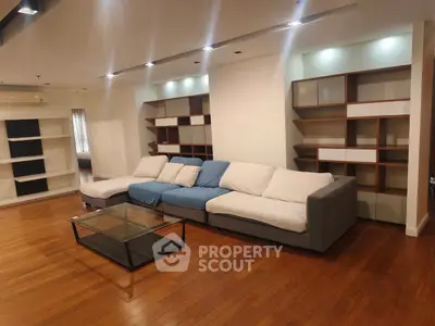 Spacious living room with modern sectional sofa and elegant wooden flooring.