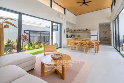 Spacious modern living room with open kitchen and garden view, featuring high ceilings and elegant decor.