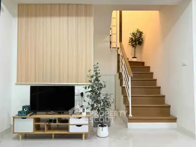 Modern living room with stylish staircase and entertainment center