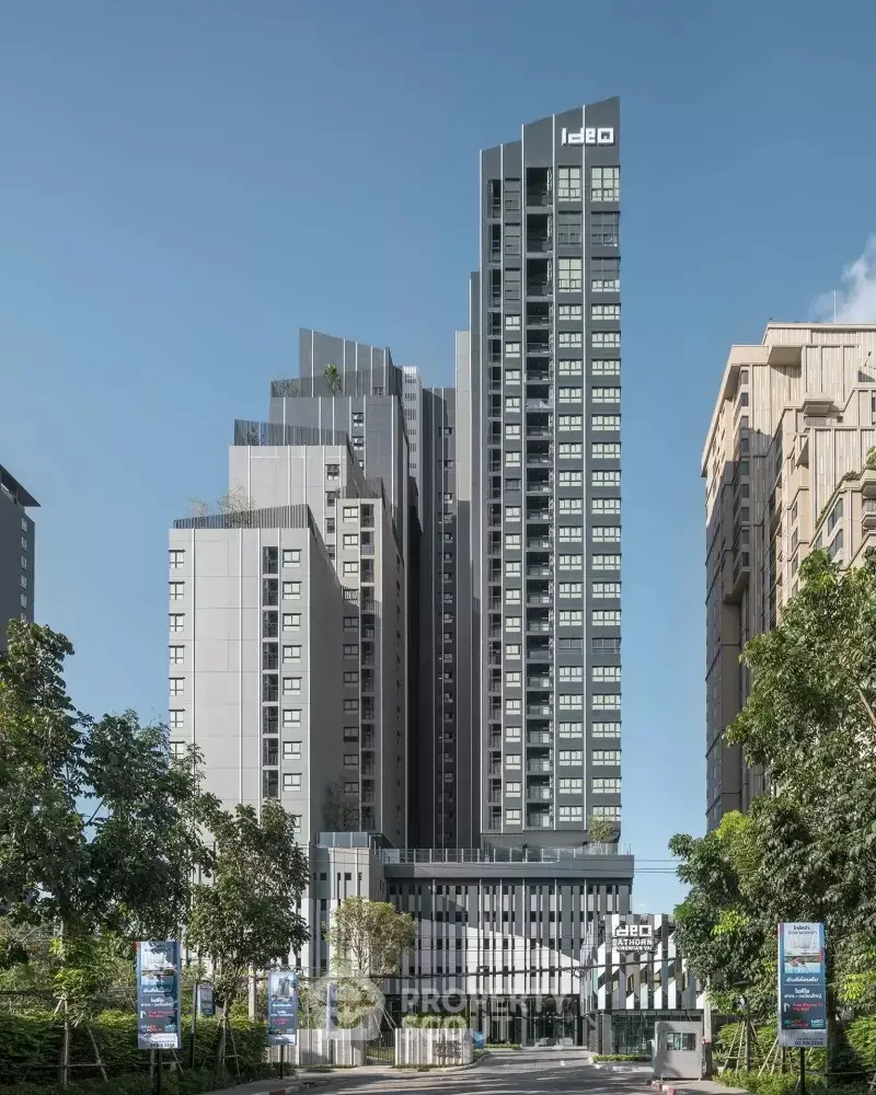 Modern high-rise residential building with sleek design and lush greenery.