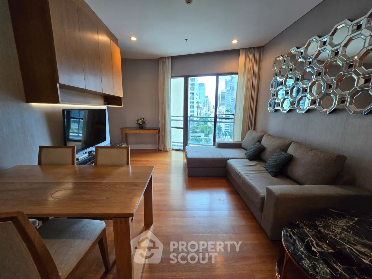 Modern living room with stylish decor and city view, featuring wooden furniture and large windows.