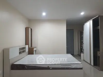 Spacious bedroom with modern furniture and ample storage space