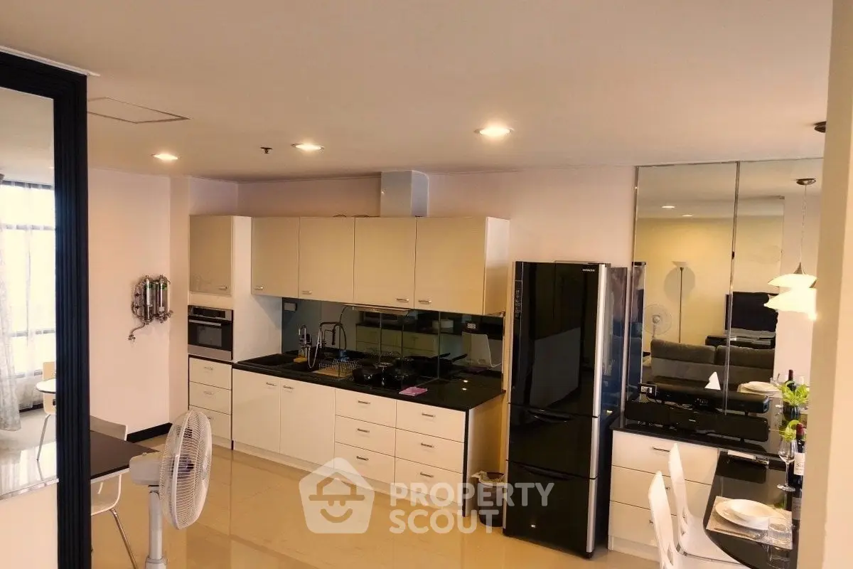 Modern kitchen with sleek black appliances and open layout in a stylish apartment.