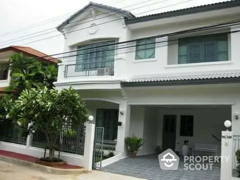 Charming two-story house with spacious driveway and lush greenery in a serene neighborhood.