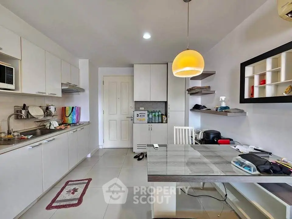 Modern kitchen with sleek cabinetry and dining area in open layout apartment.