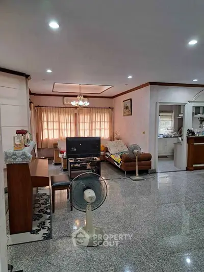 Spacious living room with elegant decor and open layout, featuring comfortable seating and ample natural light.