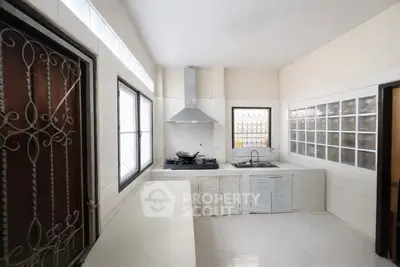 Spacious kitchen with modern gas stove and ample natural light