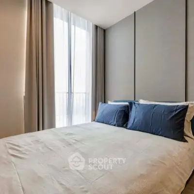 Modern bedroom with elegant decor and natural light through large window.