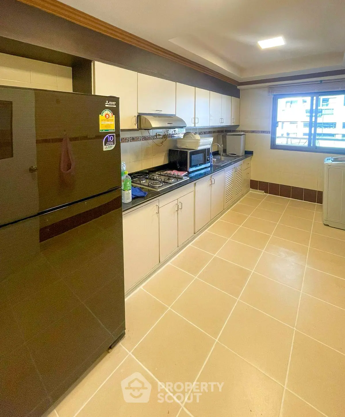 Spacious kitchen with modern appliances and ample storage in a bright apartment.