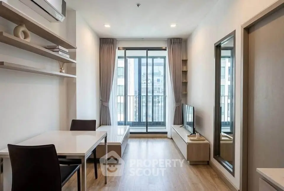 Modern living room with balcony view, sleek furniture, and natural light in a stylish apartment.