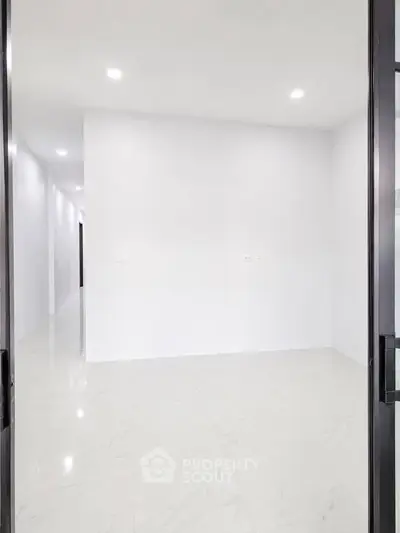 Spacious empty room with white walls and glossy tiled floor, perfect for customization.
