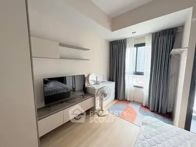 Modern bedroom with TV, fan, and large window offering city view