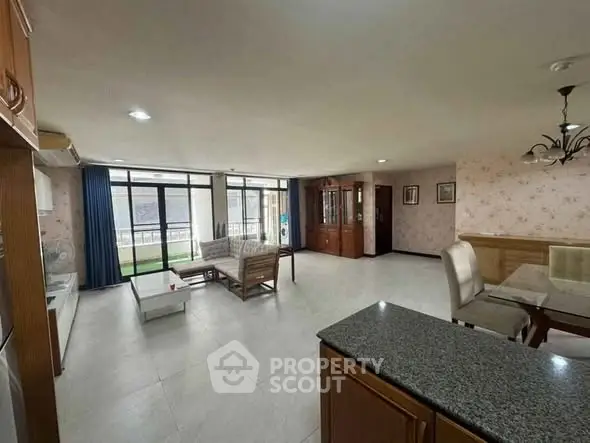 Spacious open-plan living room with elegant furniture and large windows.